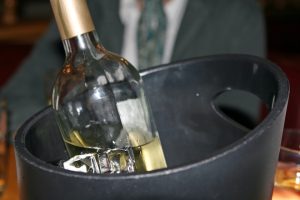 White wine bottle in an ice bucket, macro close up with copy space